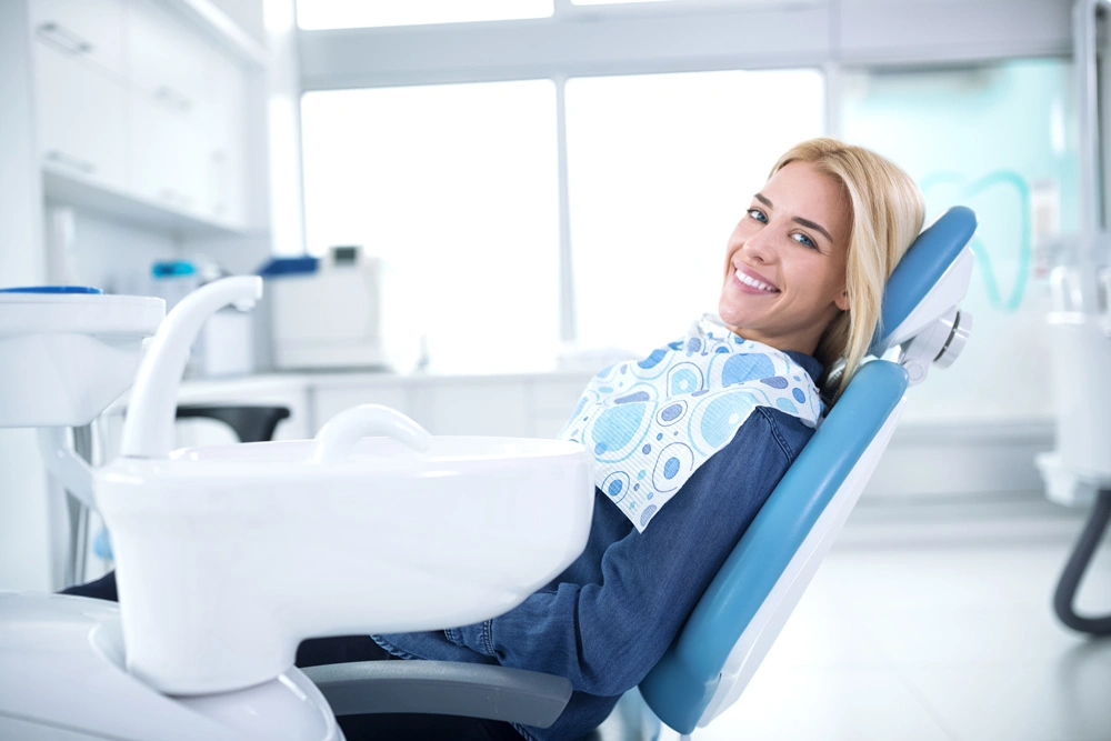 Smiling and satisfied patient in a dental office after treatment