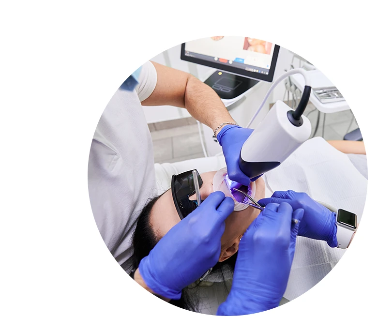 Dentist and his assistant scanning patient's teeth with modern scanning machine.